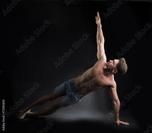 Young Sexy Shirtless Man Stretching on the Floor
