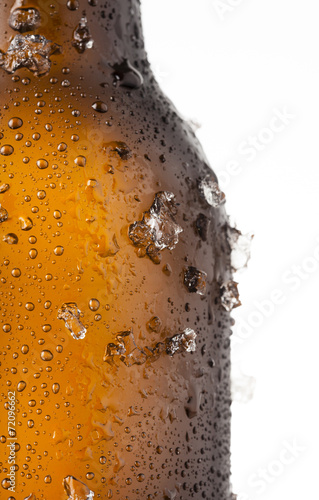 Bottle of ice cold beer with ice and drops