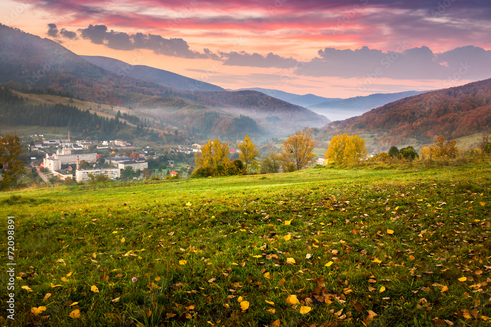 village on hillside meadow with foliage in mountain at sunrise