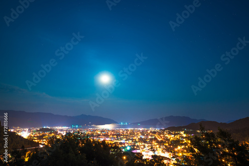 clear sky and full moon over night city