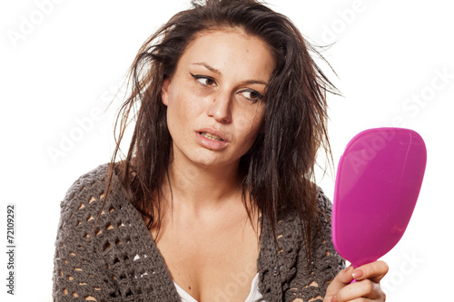 uncared messy woman looking at yourself in the mirror