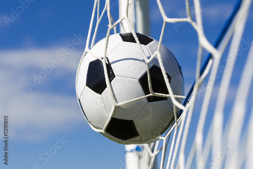 Soccer football in Goal net with sky field. © ververidis