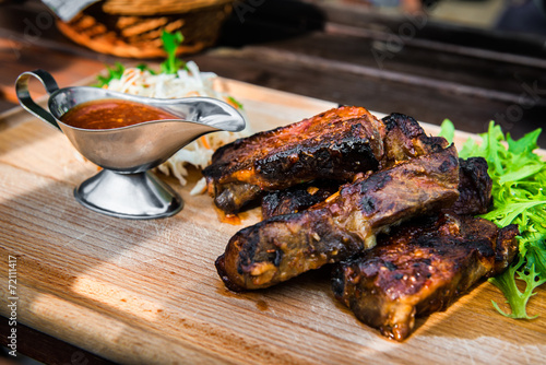 Obraz na plátně pork ribs with sauce and salad on wooden desk at the restaurant
