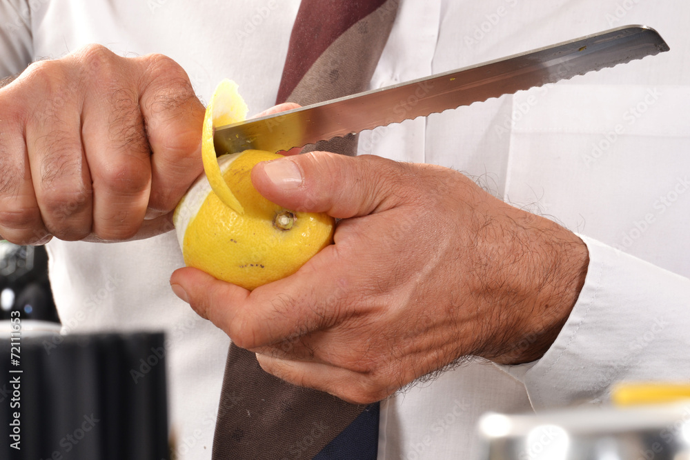 Barman pelando un limon Stock Photo