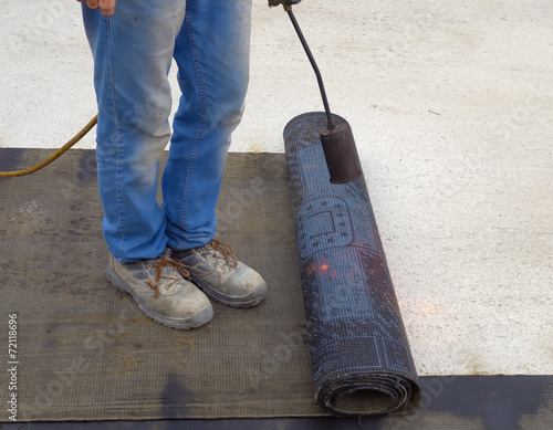 bitumen roofing felt roll for melting by gas heater torch flame photo