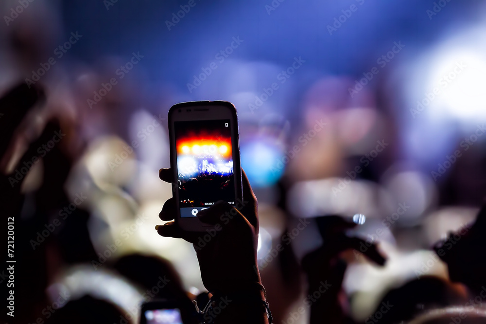 People taking photographs with touch smart phone during a music People taking photographs with touch smart phone during a music