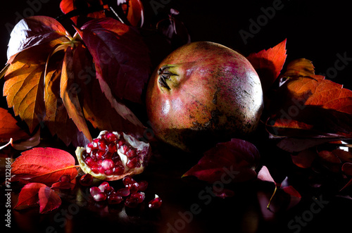 composizione melagrana con foglie rosse autunnali photo