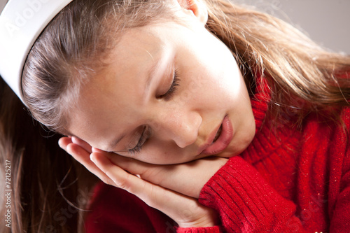 Little girl sleeping with her face on her hands