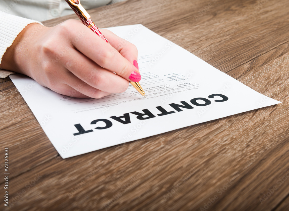 person's hand signing an important document person's hand signing an important document