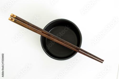 traditional empty rice bowl with bamboo chopsticks on old wood p