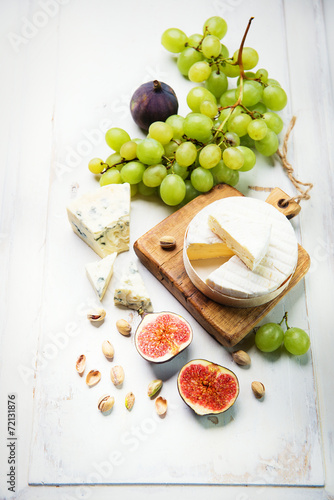 various types of cheese with figs and grapes