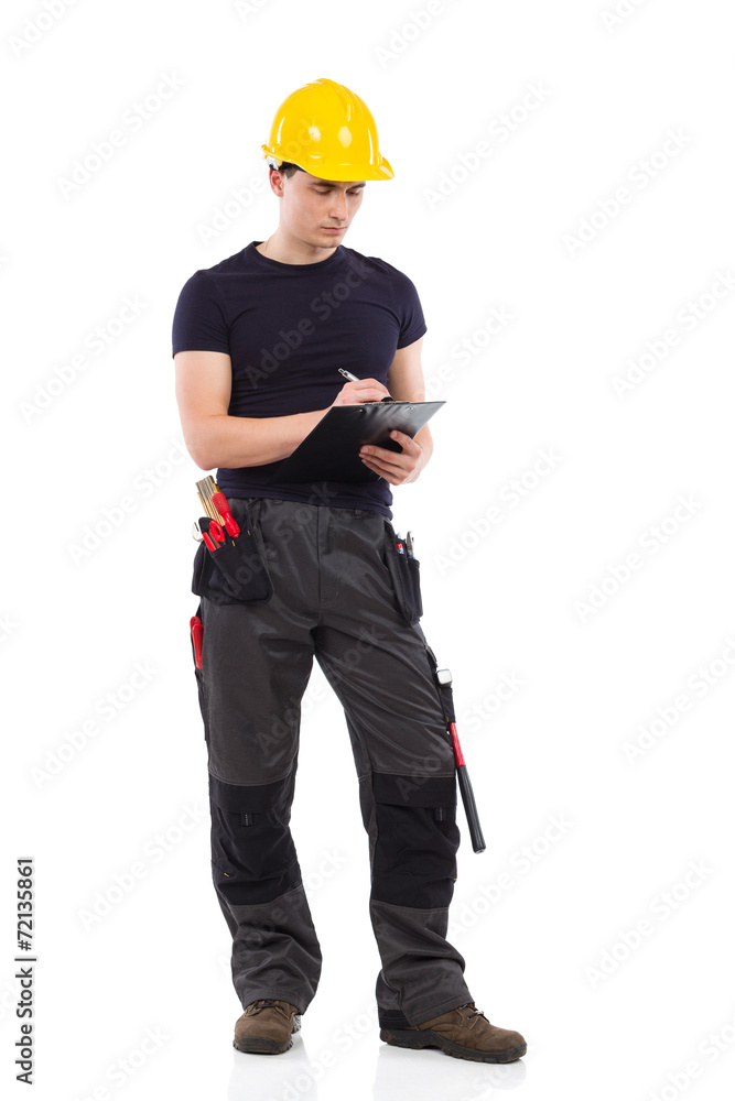 Serious construction worker taking a note. Serious construction worker taking a note.