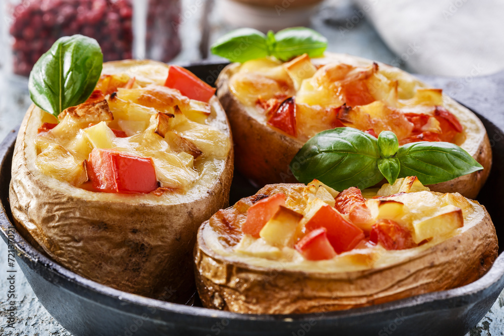 Stuffed potatoes with cheese and tomatoes in a pan