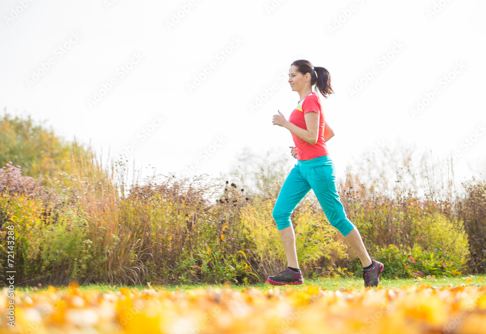 Young brunette woman running in park. Young brunette woman running in park.
