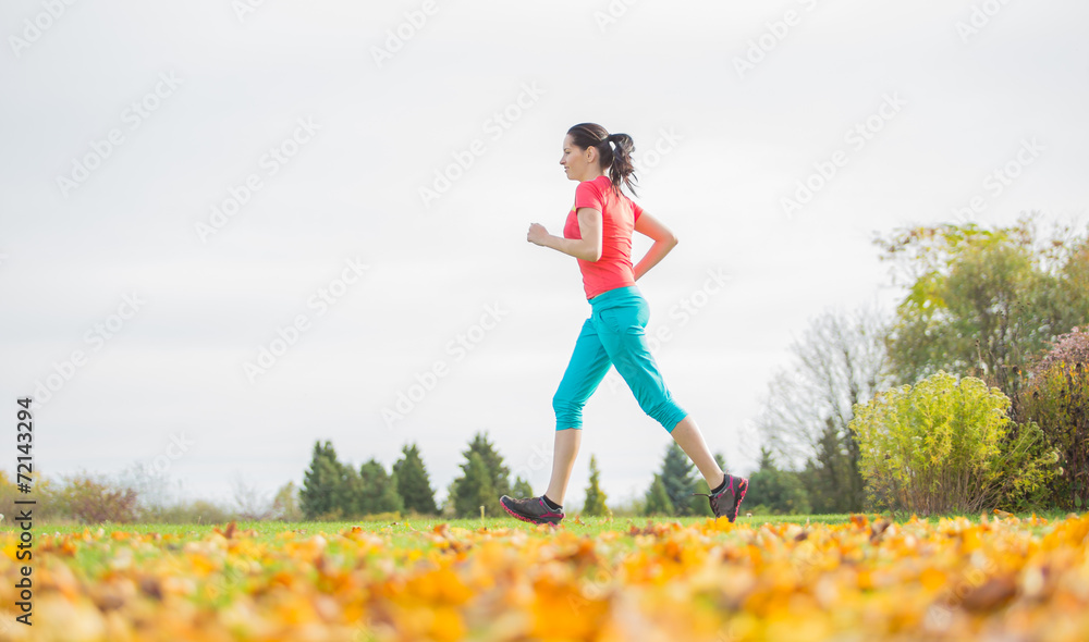 Young brunette woman running in park. Young brunette woman running in park.