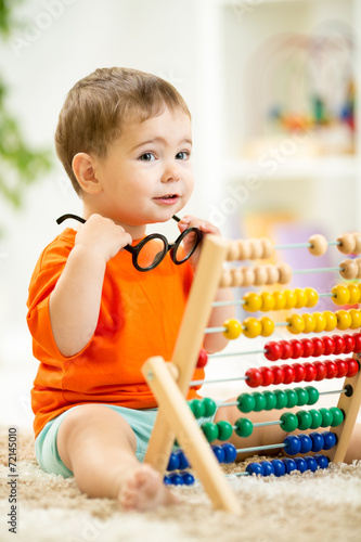 child with eyeglasses playi...
