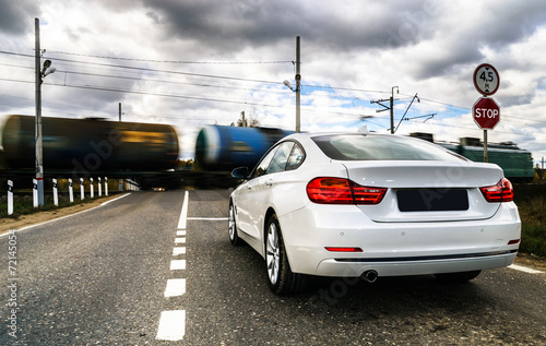 Luxury white car waiting at the railway crossing © 31etc