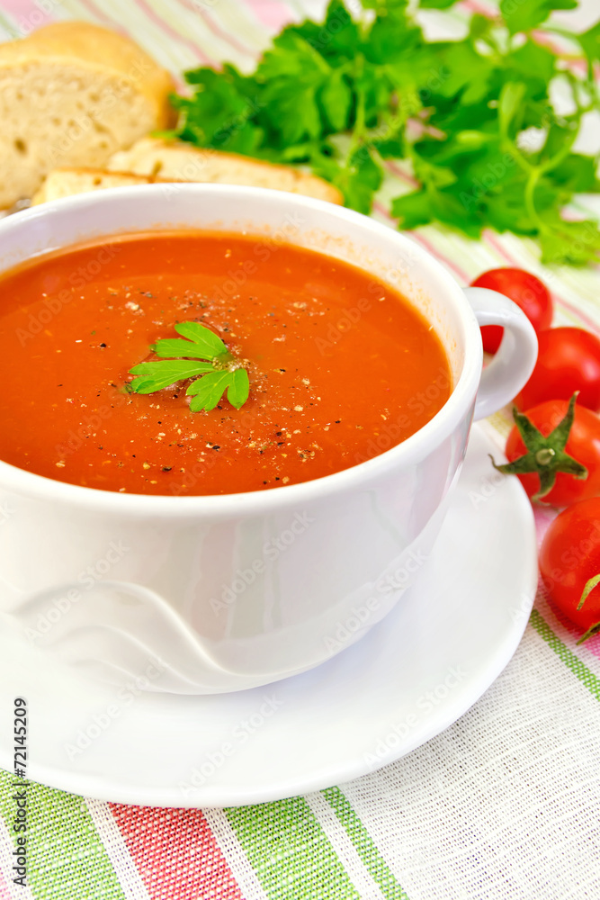 Soup tomato in bowl with tomatoes on linen napkin Soup tomato in bowl with tomatoes on linen napkin