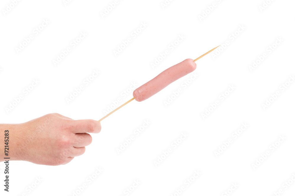 Hand holds sausage on stick Hand holds sausage on stick
