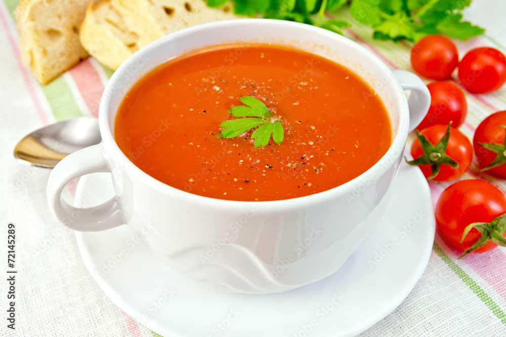 Soup tomato with peppers in bowl on linen napkin Soup tomato with peppers in bowl on linen napkin