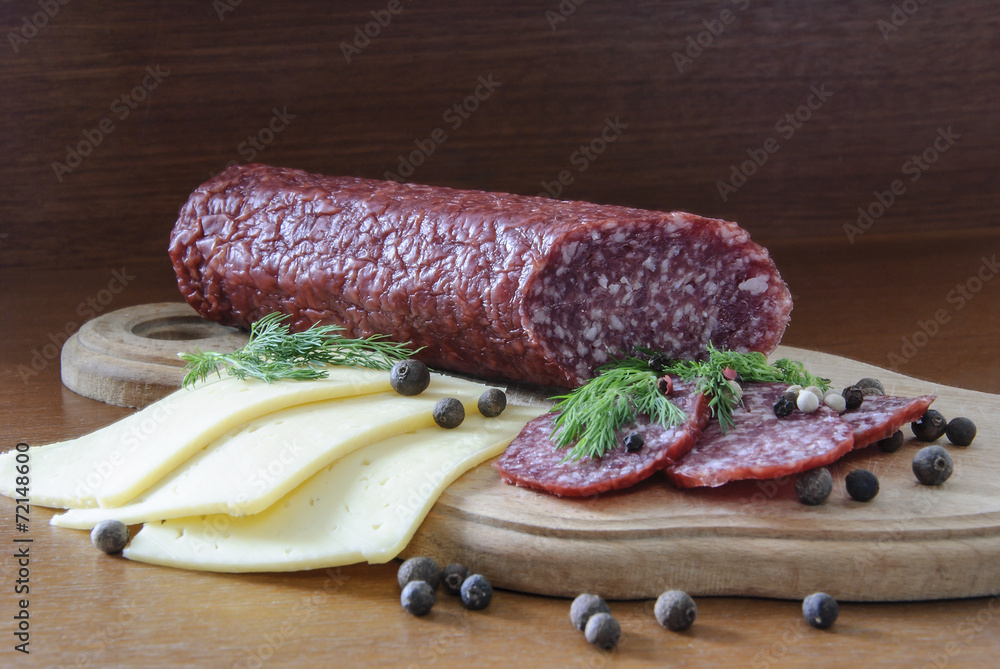 cheese sausage spices on a wooden board and a dark background cheese sausage spices on a wooden board and a dark background