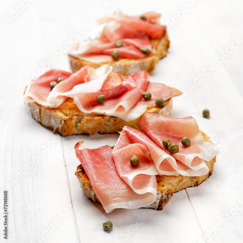Grilled country bread with ham and capers photo