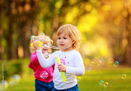 Happy kids with soap bubbles in the park. fun,emotions