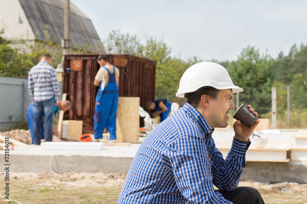 Workman drinking coffee on a building site