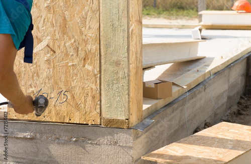 Construction worker installing wall insulation