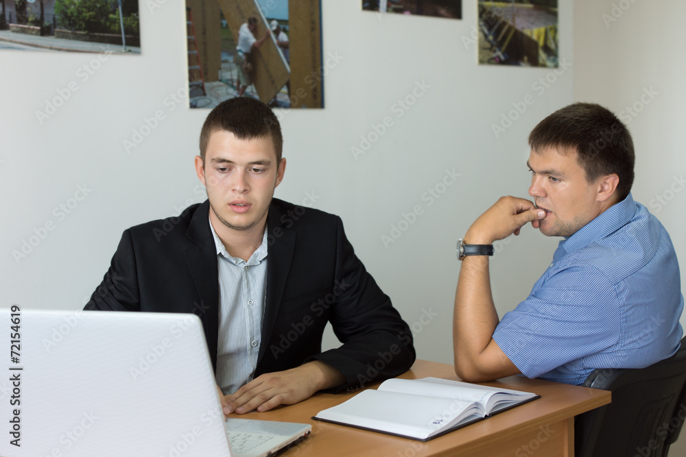 Young Businessmen Looking at Computer Seriously Young Businessmen Looking at Computer Seriously