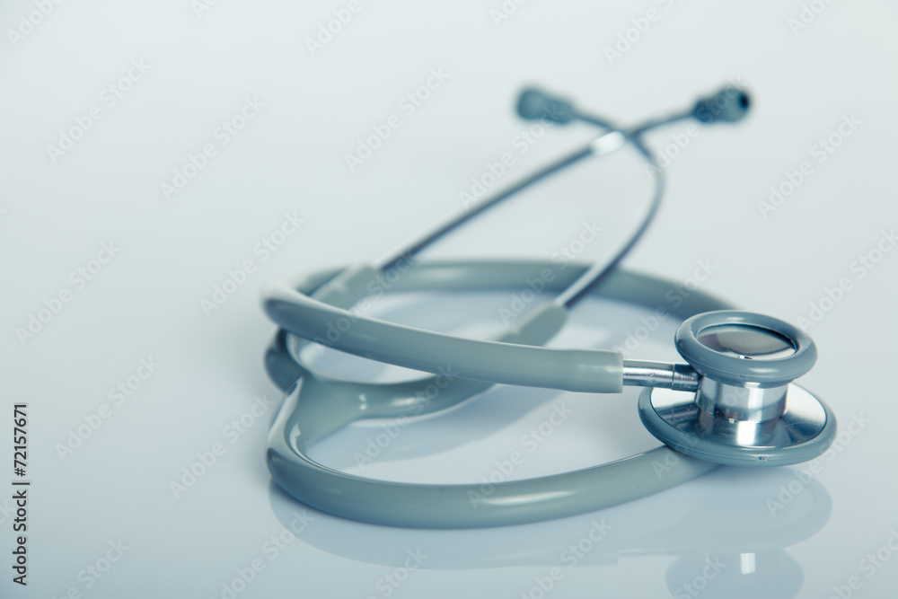 Gray stethoscope on white glossy table Gray stethoscope on white glossy table