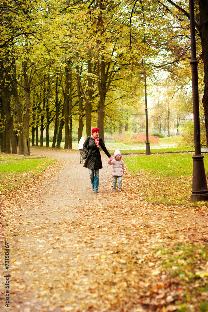 Mom and daughter walk in autumn park