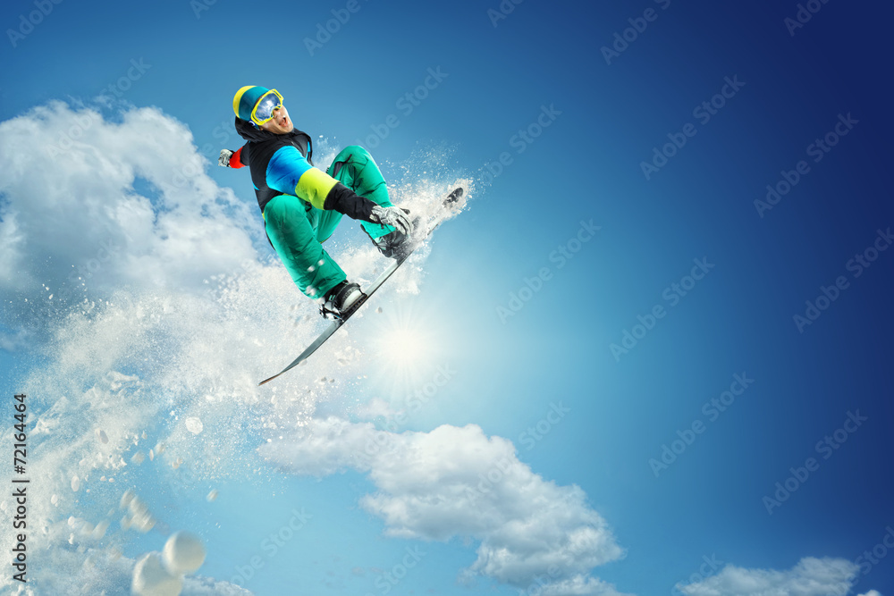 Snowboarder jumping against blue sky - obrazy, fototapety, plakaty 