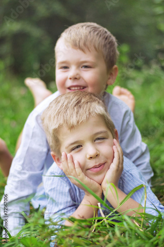 Two litle brothers relaxing on a grass