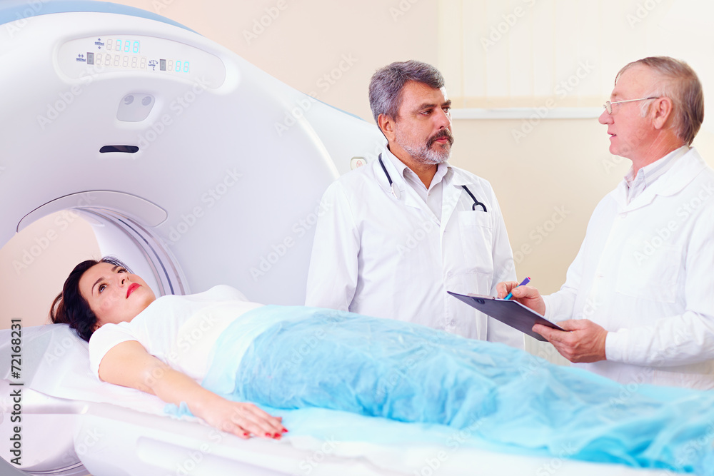 two doctors preparing patient to CT scanner procedure two doctors preparing patient to CT scanner procedure