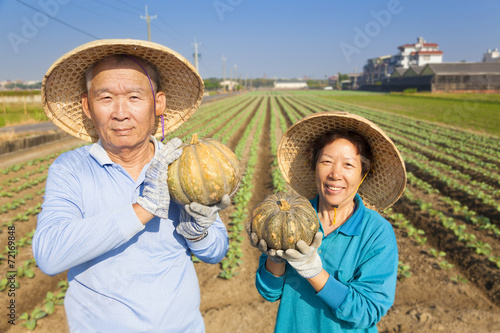 Photography asian senior couple farmer holding pumpkin on his farm