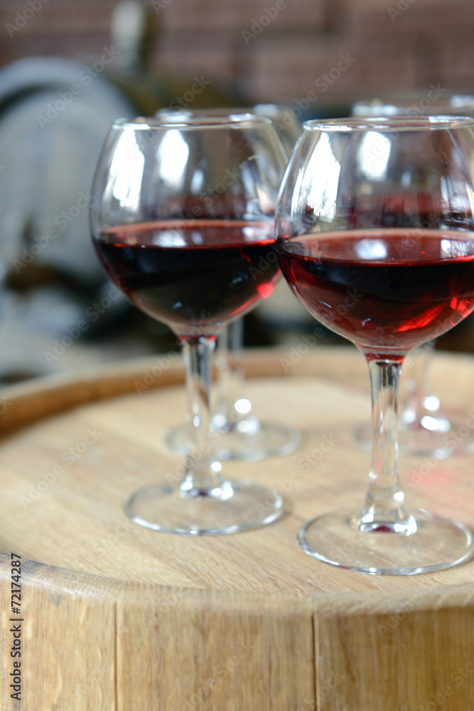 Glasses of wine in cellar with old barrels Glasses of wine in cellar with old barrels