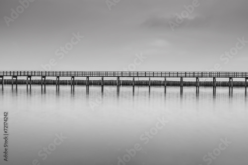 Calm scene in black and white of wooden bridge #72174242