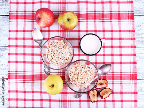 Oatmeal in bowls, mug of milk and apples
