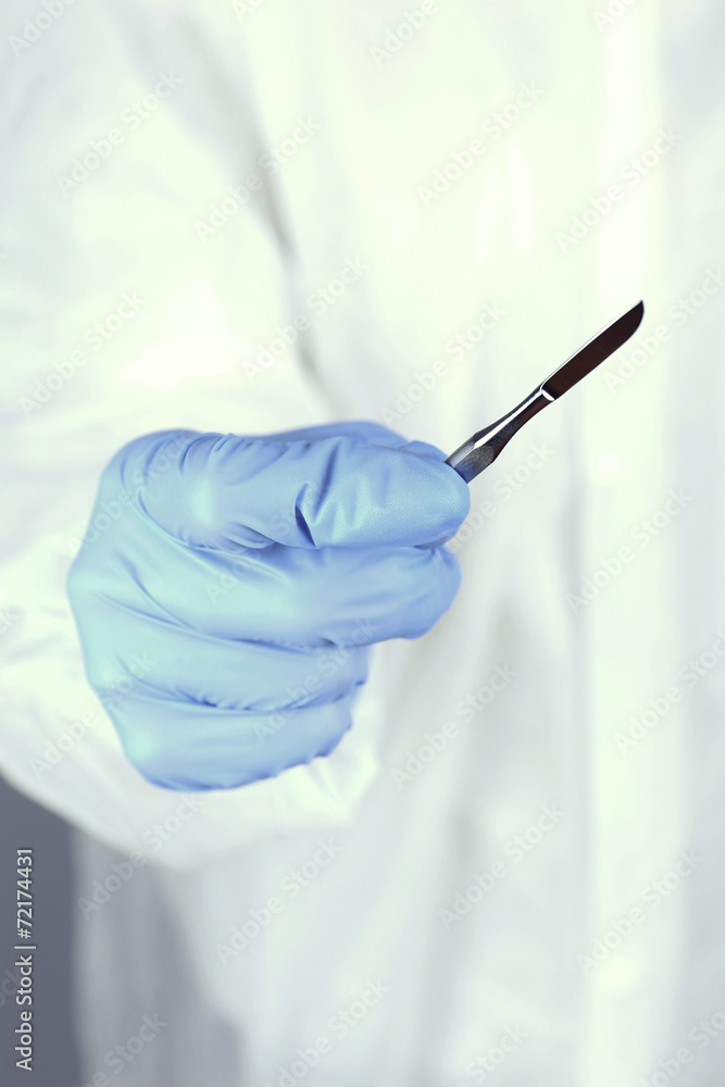 Surgeon's hand holding scalpel closeup Surgeon's hand holding scalpel closeup
