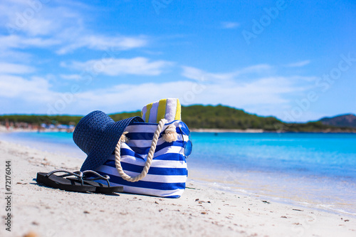 Blue bag, straw hat, flip flops and towel on white tropical © travnikovstudio