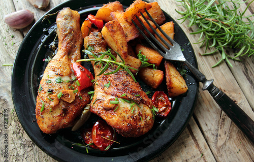 Hot roasted chicken legs with fried potatoes