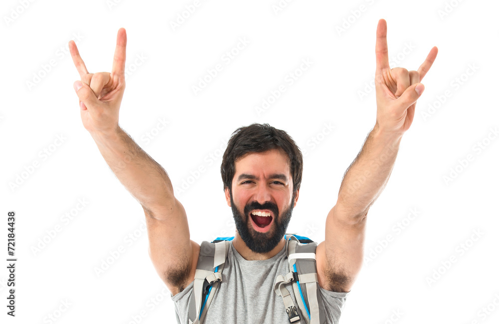 Backpacker making horn gesture over white background Backpacker making horn gesture over white background