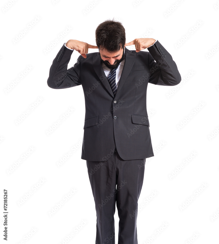 Businessman covering his ears over white background Businessman covering his ears over white background