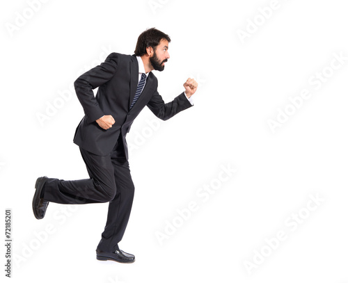 Businessman running fast over white background © luismolinero