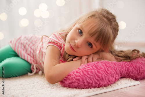 Cute little girl enjoying lying on the floor at home. Holiday li © tananddda