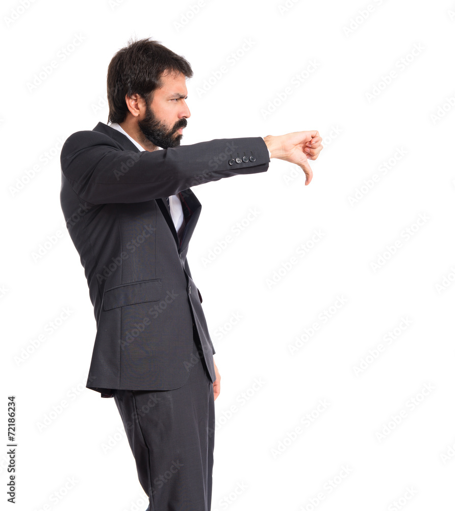 Businessman doing a bad signal over white background Businessman doing a bad signal over white background