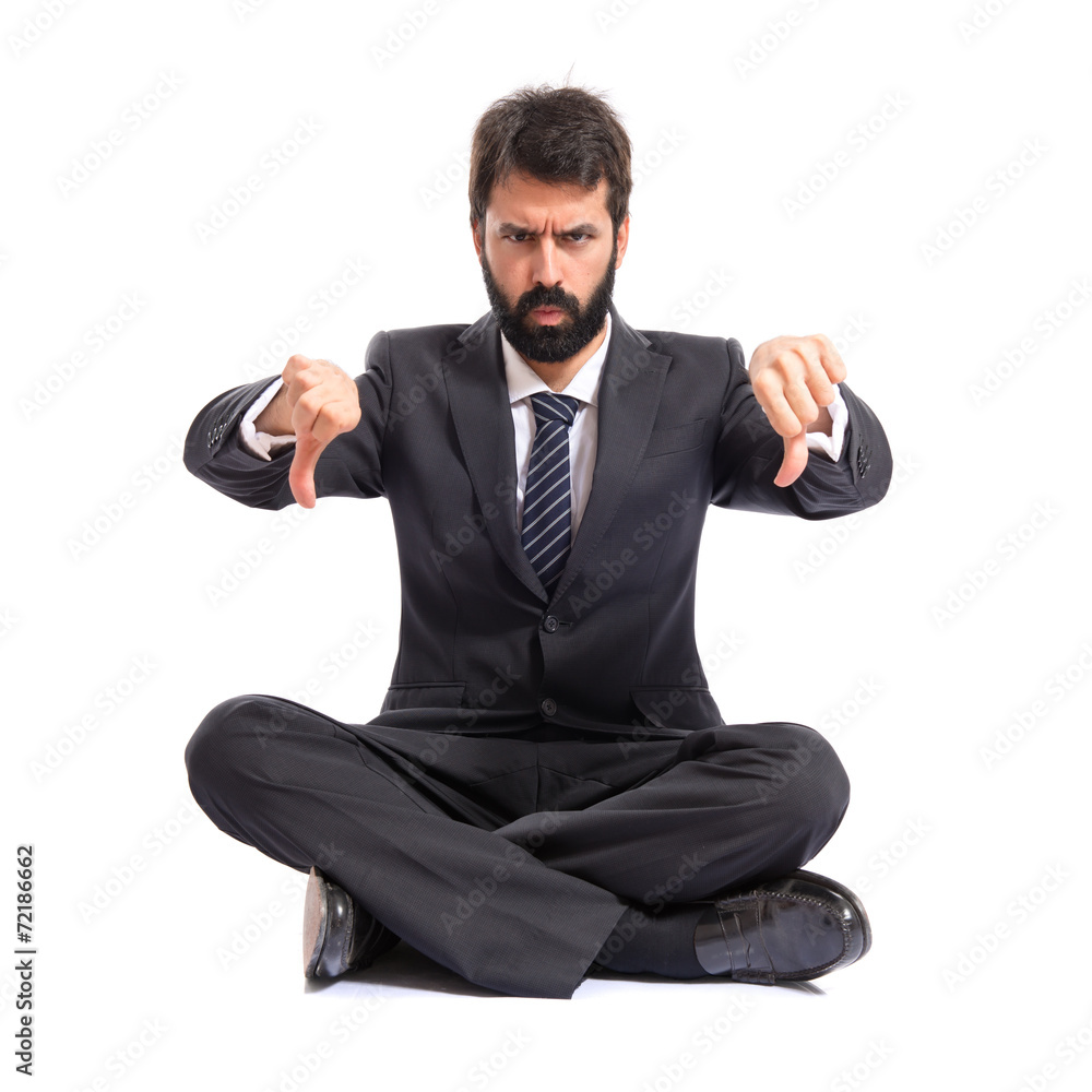 Businessman doing a bad signal over white background Businessman doing a bad signal over white background