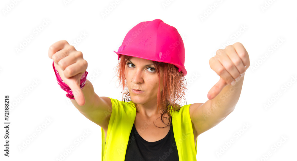 Worker woman doing a bad signal over white background Worker woman doing a bad signal over white background