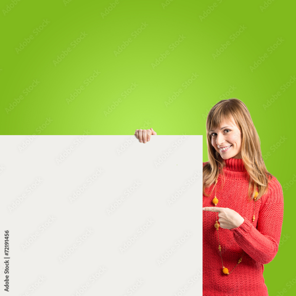 Woman with empty placard over green background Woman with empty placard over green background